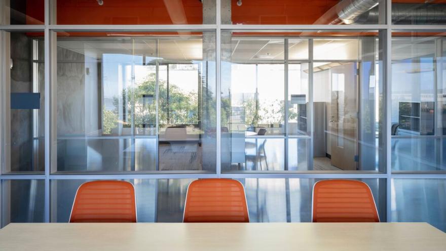 Orange furniture, lots of glass (some translucent) and natural light, views of nearby offices, an orange accent wall in the hallway, juxtaposed with industrial fixtures like cement poles and walls lends a retro-artistic and stimulating feel to this conference work environment that UCSF Human Resources will soon occupy in the newly renovated 2001 The Embarcadero.